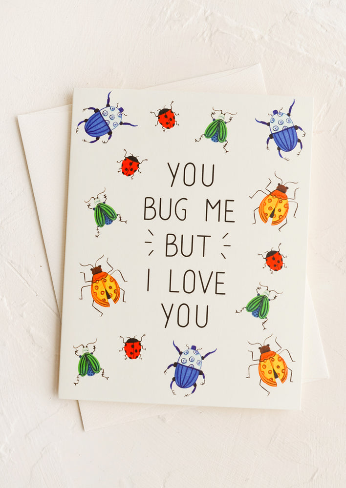 A greeting card with insect print and text reads "You bug me but I love you".