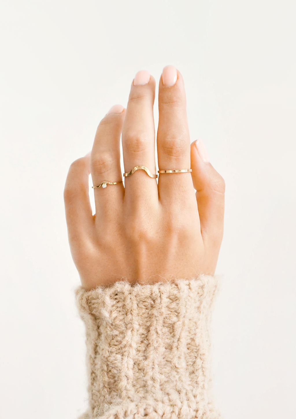 2: Model shot of hand wearing three different styles of rings.