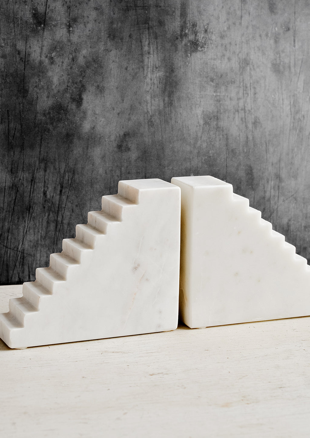 1: A pair of white marble bookends with staircase design.