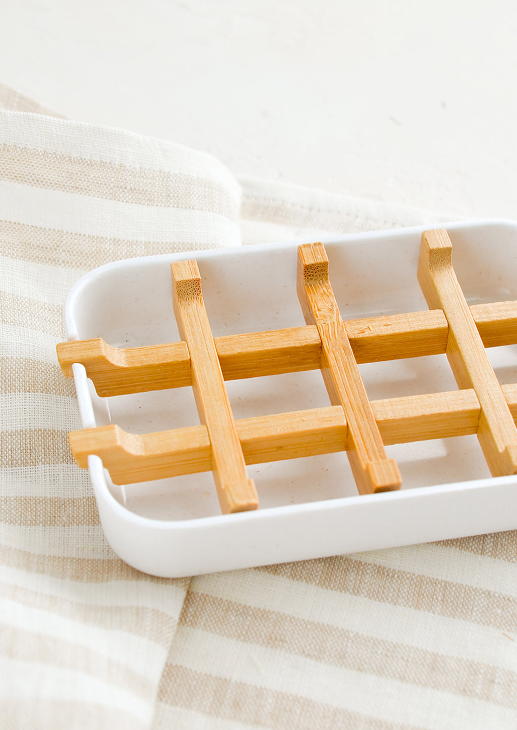 2: A white soap dish with built-in bamboo drainage tray.
