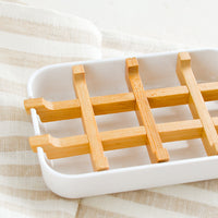 2: A white soap dish with built-in bamboo drainage tray.