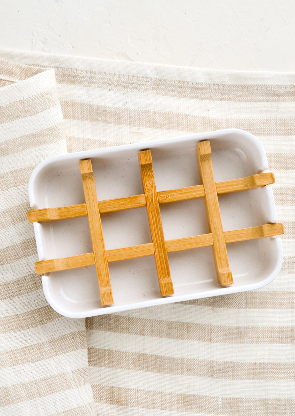 1: A white soap dish with built-in bamboo drainage tray.