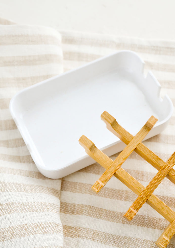 A white soap dish with built-in removable bamboo drainage tray.
