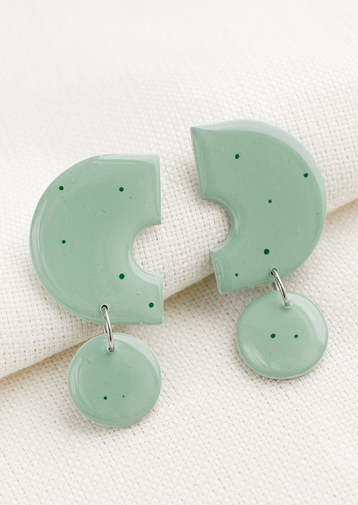 Seafoam: A pair of clay earrings with geometric shape in seafoam with green splatters.